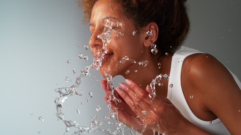 Person spritzt sich kaltes Wasser ins Gesicht als somatischen Reiz